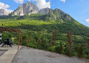 a picnic shelter with mountains in the background at Visi Cabins Bogë in Bogë