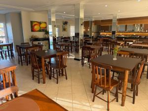 a restaurant with wooden tables and chairs in it at Hotel Morada do Sol in Chavantina