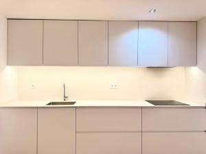 a white kitchen with white cabinets and a sink at Mouzinho Living Centro & Mar in Póvoa de Varzim