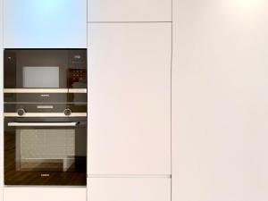a kitchen with white cabinets and a microwave at Mouzinho Living Centro & Mar in Póvoa de Varzim +20 photos