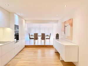 a kitchen with white cabinets and a dining room at Mouzinho Living Centro & Mar in Póvoa de Varzim