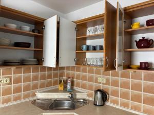 a kitchen with wooden cabinets and a sink at Ubytování Jívka 86 in Jívka +61 photos