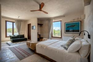 a bedroom with a large bed and a ceiling fan at Masseria Guadalupe, The Mascienda in Ostuni