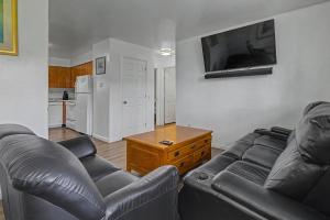 a living room with two leather couches and a flat screen tv at 410 e45th 2 bedroom apartment in Anchorage