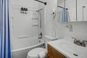 a white bathroom with a toilet and a sink at 410 e45th 2 bedroom apartment in Anchorage +29 photos