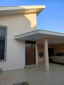 a house with a car parked in front of it at Pousada Brisa da Mata in Londrina +6 photos