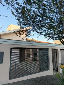 a house with blinds on the side of it at Pousada Brisa da Mata in Londrina