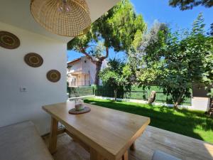 a wooden table in a room with a view of a yard at Nunu GARDEN Urla in Urla