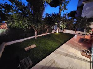 a backyard with a lawn with trees and a fence at Nunu GARDEN Urla in Urla +5 photos