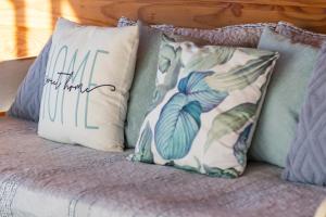 a bed with pillows and a sign that reads one more mum at Petricor Ecolodge Cab2 in Pucón