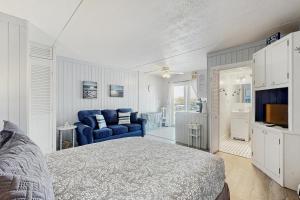a bedroom with a bed and a couch and a television at Salty Breeze Studio in Wells
