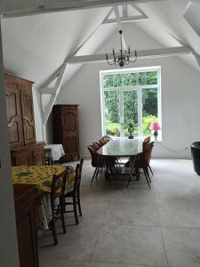 a dining room with a table and chairs and a window at Domaine le bas bois in Neuville-sur-Sarthe