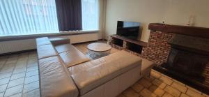 a living room with a couch and a fireplace at CoSY HOME in Mortsel