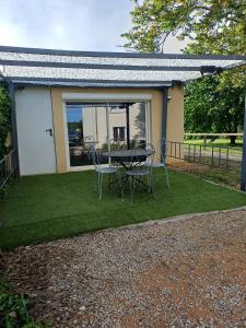 a table and chairs on a lawn in front of a house at Studio a la campagne in Dissay