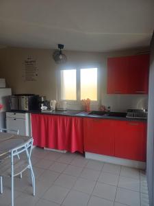 a kitchen with red cabinets and a red counter top at Studio a la campagne in Dissay