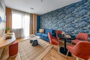 a living room with a blue couch and red chairs at Lazuli Apartment in Hegykő