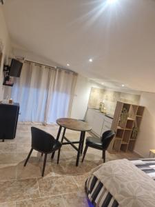 a room with a table and two chairs and a kitchen at Petit appartement avec jacuzzi in Bédarrides