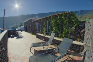 a group of chairs sitting on a stone wall at Casa La Tabona in Frontera