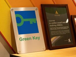 a sign for a green key next to a frame at ibis Styles Kyoto Shijo in Kyoto +102 photos