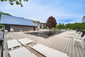 a deck with white chairs and a swimming pool at Only 8/22-8/29 Still Available for Summer 2026! in Harbor Springs