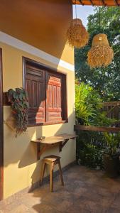 a wooden bench next to a building with a window at Vila Rudá - Alter do Chão in Alter do Chao
