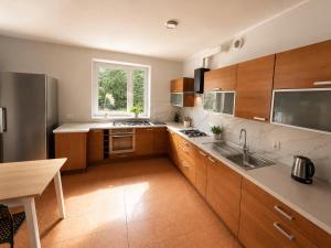 a large kitchen with wooden cabinets and a sink at Dom Winnica noclegi in Sochaczew +5 photos