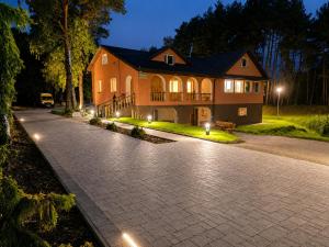 a house with a stone driveway at night at Dom Winnica noclegi in Sochaczew