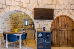 a kitchen with a table and a stone wall at Trulli boutique & suite in Santa Lucia