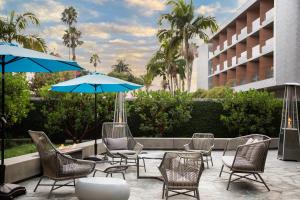a patio with chairs and umbrellas in front of a building at Shore Hotel in Los Angeles