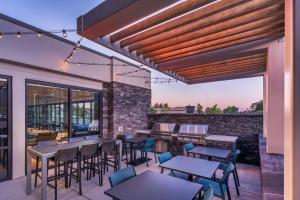 a patio with tables and chairs and a brick wall at Home2 Suites By Hilton Carson City in Carson City