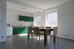 a kitchen with a dining room table and chairs at Apartmánový dům ROTOR in Kunowitz