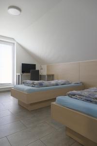 two beds in a room with a desk and a television at Apartmánový dům ROTOR in Kunowitz