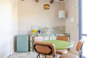 a kitchen with a green table and chairs in a room at Trulli boutique & suite in Santa Lucia