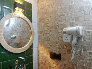 a mirror and a hair dryer on a bathroom wall at Riad la Fíbula de Nora in Fez