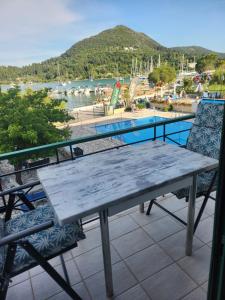 a picnic table and chairs on a balcony with a view of a pool at MSK Studios in Nydri +8 photos