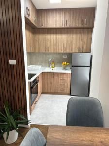 a kitchen with wooden cabinets and a refrigerator at New Bubanj Apartment 3 in Kragujevac