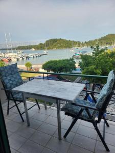 a table and chairs on a balcony with a view of a harbor at MSK Studios in Nydri