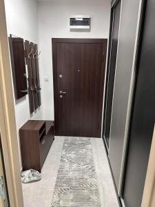 a bathroom with a brown door and a tile floor at New Bubanj Apartment 3 in Kragujevac
