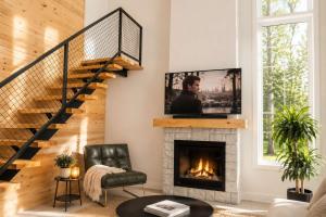 a living room with a fireplace with a tv above it at Lake Spa and Pool table - Le Gaia in Chertsey