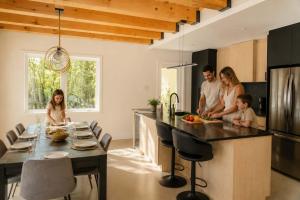 a family standing in a kitchen with a table at Lake Spa and Pool table - Le Gaia in Chertsey