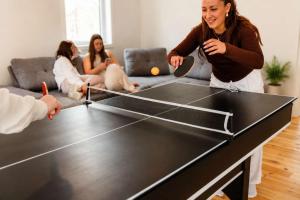 a woman playing a game of ping pong at Lake Spa and Pool table - Le Gaia in Chertsey +25 photos
