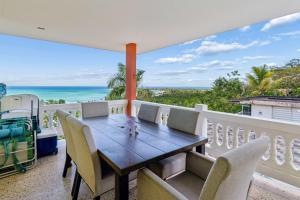 a table and chairs on a balcony with a view of the ocean at Villa Marbella - Ocean Views & Private Pool in Luquillo