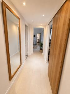 a hallway of a house with a mirror on the wall at Downtown Terrace with panoramic view in Tourcoing +1 photo