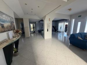 a living room with a blue couch and a table at GianAngelo Holiday Villa in Kremasti +51 photos