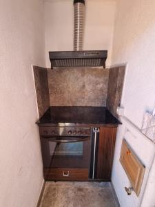 a small kitchen with a stove and a hood at VILA 32 in Berat +9 photos