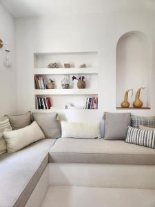 a white living room with a couch and books at Nunu HOUSE Urla in Urla