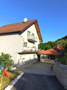 a white house with a parking lot in front of it at Stefke 2 in Lučani