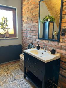 a bathroom with a sink and a brick wall at Górska Chata w Górach Bystrzyckich in Niemojów +44 photos