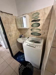 a small bathroom with a sink and a washing machine at F2 Tahiti Lagoon Stays in Punaauia +17 photos