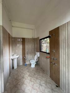 a bathroom with a toilet and a sink at Kopou Homestay in Jorhat